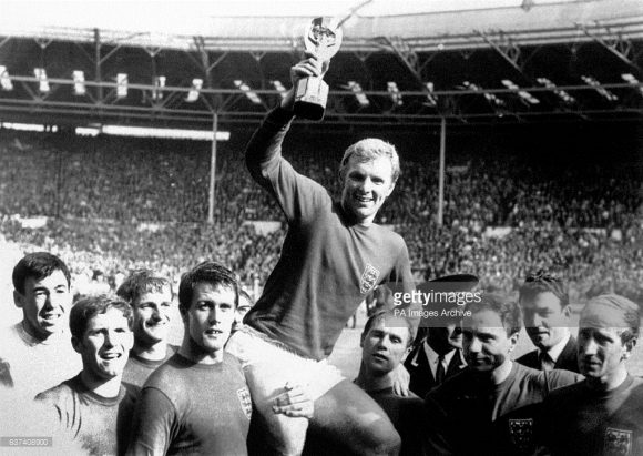 A lenda Bobby Moore exibi com orgulho, a única taça de Copa do Mundo da Inglaterra, conquistada em 1966, no estádio de Wembley.