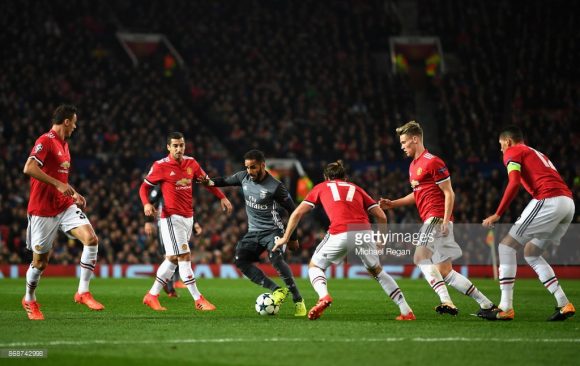 O brasileiro Douglas (Benfica) é cercado por cinco jogadores do Manchester United na partida da última quarta-feira pela Champions League. Através desta imagem fica nítida a eficiência defensiva do Manchester United.